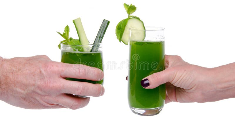 La mano de la mujer y del hombre que hace la tostada con los vidrios de jui del pepino foto de archivo libre de regalías La mano de la mujer y del hombre que hace la tostada con los vidrios de jui del pepino foto de archivo libre de regalías