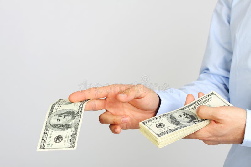 La mano de los hombres que lleva a cabo billetes de dólar del americano ciento del dinero Mano del dinero de ofrecimiento del hom fotografía de archivo La mano de los hombres que lleva a cabo billetes de dólar del americano ciento del dinero Mano del dinero de ofrecimiento del hom fotografía de archivo