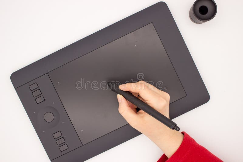 La mano de una mujer en una manga roja dibuja una aguja en una tableta de gráficos imagen de archivo La mano de una mujer en una manga roja dibuja una aguja en una tableta de gráficos imagen de archivo