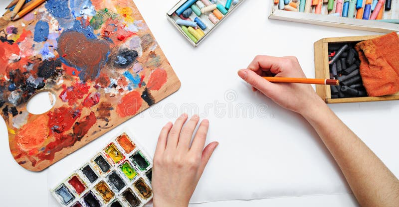 La mano del artista en el trabajo, las pinturas, los cepillos y los lápices fotografía de archivo La mano del artista en el trabajo, las pinturas, los cepillos y los lápices fotografía de archivo