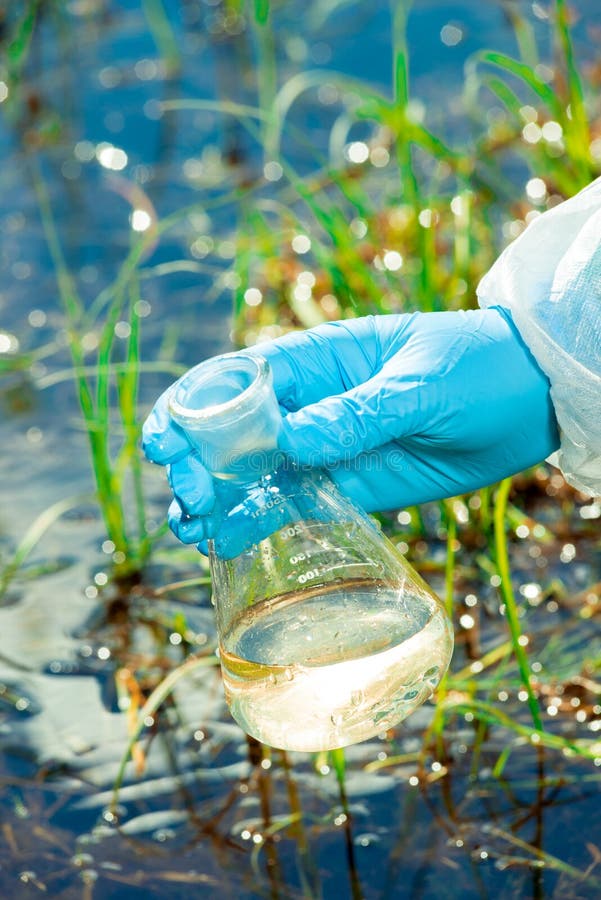 La mano del ecologista con un frasco produce un sistema de agua para la investigaci?n foto de archivo La mano del ecologista con un frasco produce un sistema de agua para la investigaci?n foto de archivo