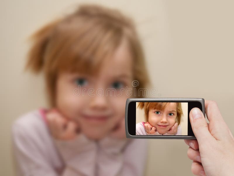 La Mano Del Hombre Que Hace La Foto De Una Niña Con Un Teléfono Móvil Imagen De Archivo 8935