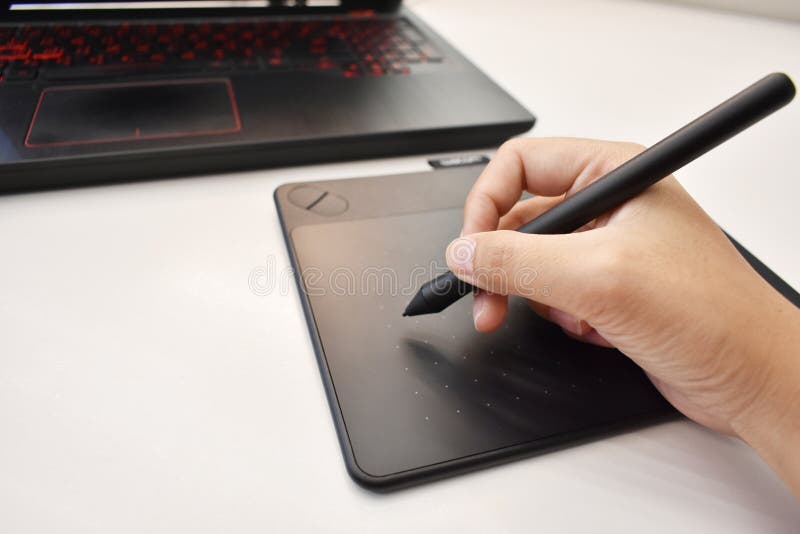 La mano del hombre usando el ratón inalámbrico de la pluma para dibujar fotos de archivo La mano del hombre usando el ratón inalámbrico de la pluma para dibujar fotos de archivo