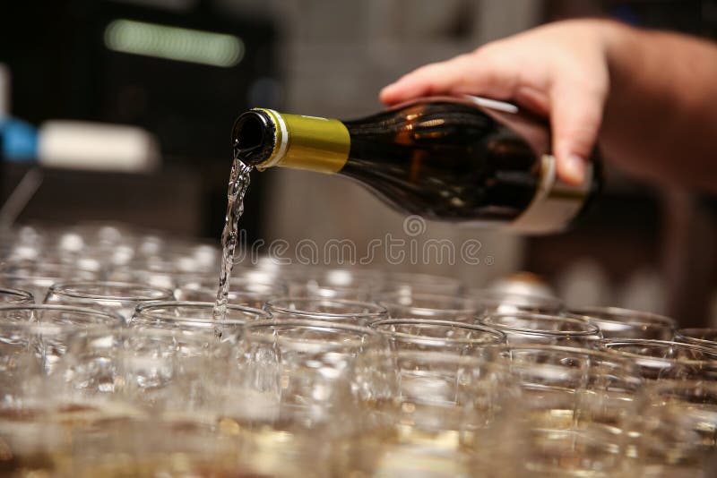 La mano del hombre vierte el vino en los vidrios foto de archivo libre de regalías La mano del hombre vierte el vino en los vidrios foto de archivo libre de regalías
