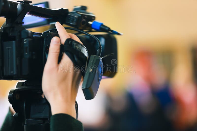 La mano dell'uomo tiene la videocamera nera digitale fotografia stock La mano dell'uomo tiene la videocamera nera digitale fotografia stock