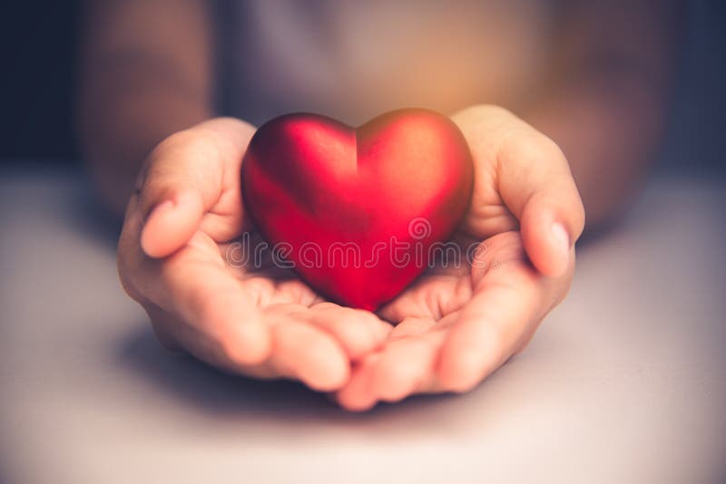 La mano dà il cuore rosso per amore
