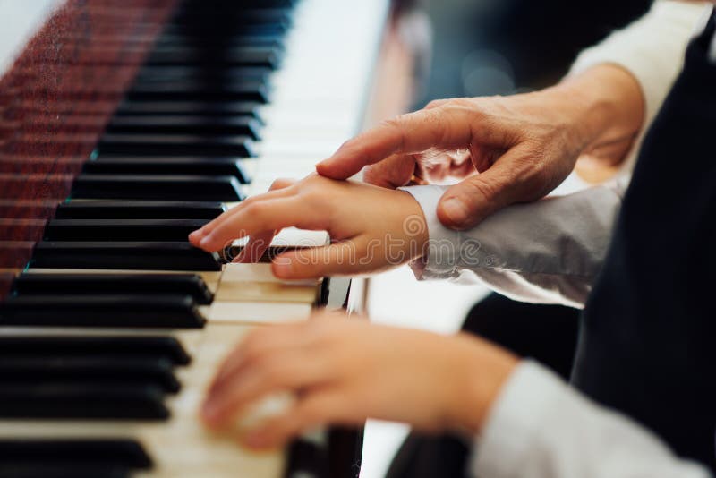 La mano experimentada del viejo profesor de música ayuda al alumno del niño fotos de archivo libres de regalías La mano experimentada del viejo profesor de música ayuda al alumno del niño fotos de archivo libres de regalías