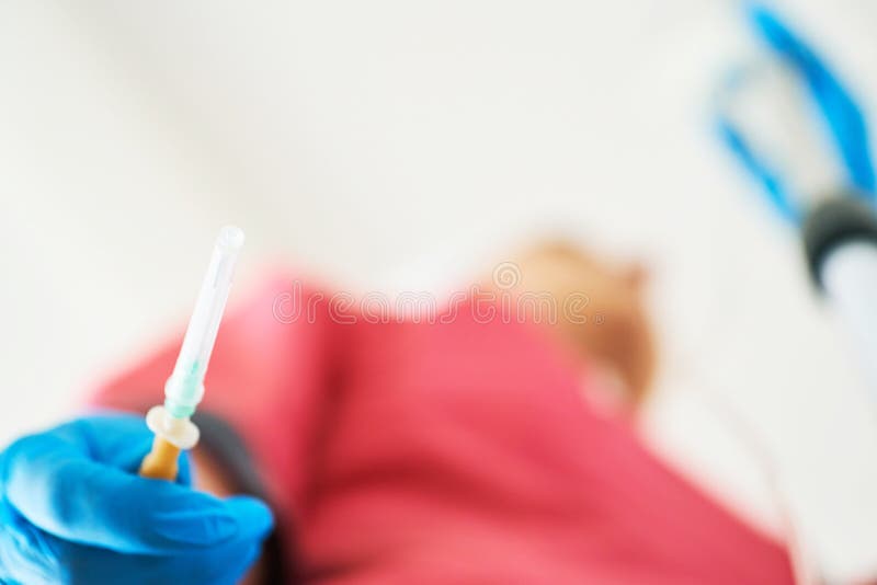 La mano in guanto sterile blu tiene l'ago da un sistema di plastica del contagoccia L'infermiere è pronto a mettere un contagocci fotografie stock libere da diritti La mano in guanto sterile blu tiene l'ago da un sistema di plastica del contagoccia L'infermiere è pronto a mettere un contagocci fotografie stock libere da diritti