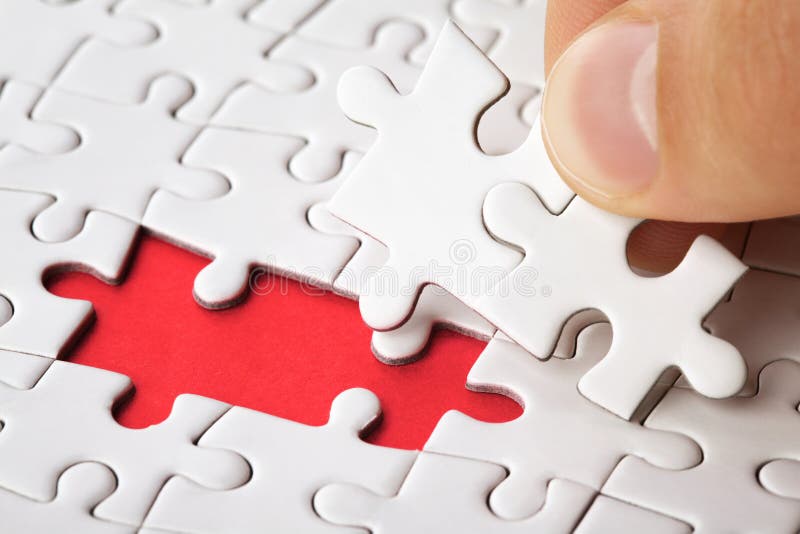 La mano ha messo l'ultimo pezzo di puzzle per completare la missione immagine stock libera da diritti La mano ha messo l'ultimo pezzo di puzzle per completare la missione immagine stock libera da diritti