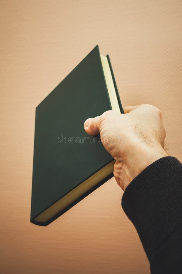 La mano maschio tiene il libro verde scuro fotografia stock libera da diritti La mano maschio tiene il libro verde scuro fotografia stock libera da diritti