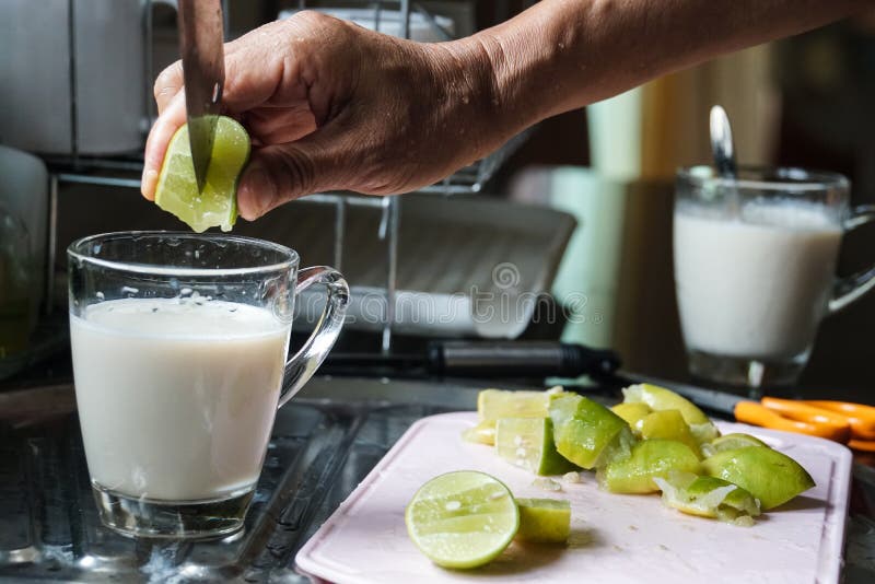 La mano masculina puso la cal en bebida de la leche de soja imagen de archivo La mano masculina puso la cal en bebida de la leche de soja imagen de archivo
