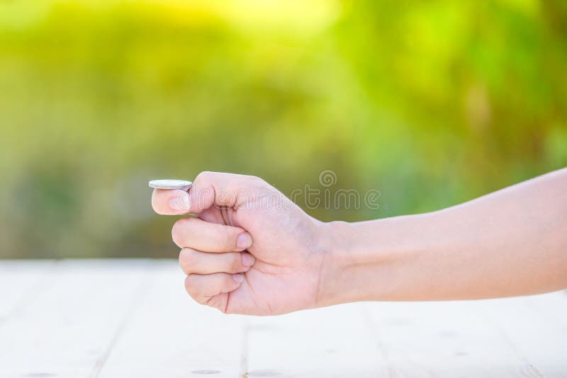 La mano prepara per la vibrazione una moneta immagine stock libera da diritti La mano prepara per la vibrazione una moneta immagine stock libera da diritti