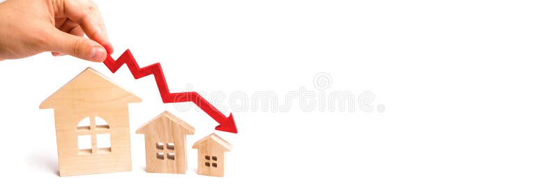 La mano sujeta una flecha roja sobre las casas de madera hacia abajo Las casas están disminuyendo El concepto de oferta y demanda foto de archivo La mano sujeta una flecha roja sobre las casas de madera hacia abajo Las casas están disminuyendo El concepto de oferta y demanda foto de archivo