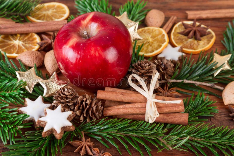 La manzana roja con las especias de la Navidad y el abeto ramifican en fondo de madera imagenes de archivo La manzana roja con las especias de la Navidad y el abeto ramifican en fondo de madera imagenes de archivo