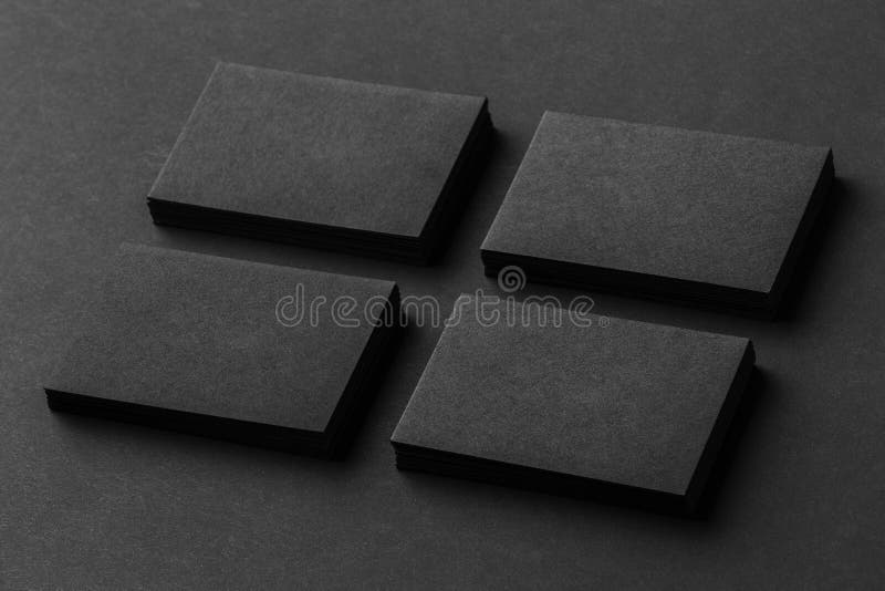 La maqueta de cuatro pilas negras de las tarjetas de visita arregló en filas en b imagen de archivo La maqueta de cuatro pilas negras de las tarjetas de visita arregló en filas en b imagen de archivo
