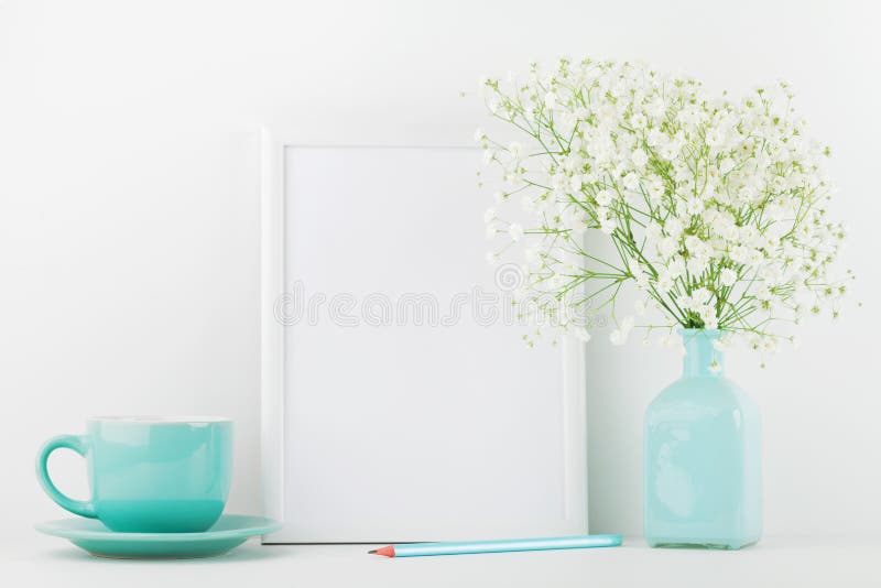 La maquette des fleurs décorées de cadre de tableau dans la tasse de vase et de café sur la table blanche avec l'espace propre po images libres de droits La maquette des fleurs décorées de cadre de tableau dans la tasse de vase et de café sur la table blanche avec l'espace propre po images libres de droits