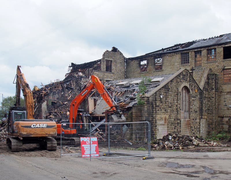 La maquinaria de construcción en la demolición del edificio del molino de los walkeys adentro hebden el puente después del fuego foto de archivo La maquinaria de construcción en la demolición del edificio del molino de los walkeys adentro hebden el puente después del fuego foto de archivo