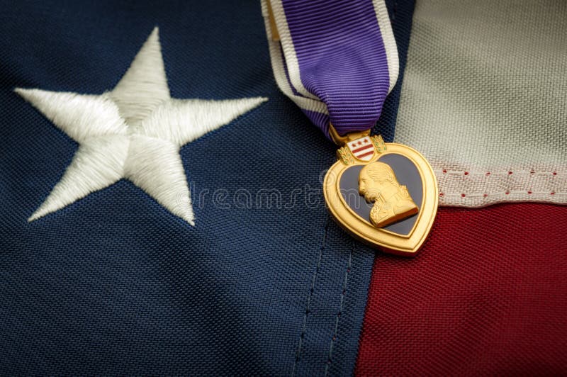La medaglia di Purple Heart e la bandiera americana fotografia stock libera da diritti La medaglia di Purple Heart e la bandiera americana fotografia stock libera da diritti
