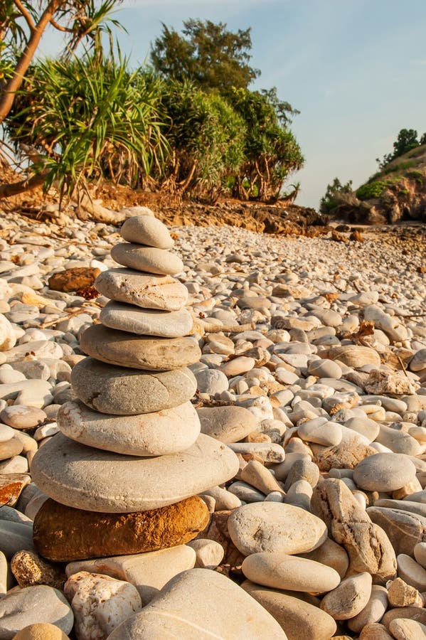 La meditación del zen del mojón, piedras equilibra en la playa de piedra, árboles tropicales y la montaña empañó fondos Isla de L imágenes de archivo libres de regalías La meditación del zen del mojón, piedras equilibra en la playa de piedra, árboles tropicales y la montaña empañó fondos Isla de L imágenes de archivo libres de regalías