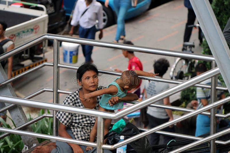 La mendiante de mère et de bébé sur la passerelle à la jonction croisent entre Anawrahta Rd et Sule Pagoda Rd images libres de droits La mendiante de mère et de bébé sur la passerelle à la jonction croisent entre Anawrahta Rd et Sule Pagoda Rd images libres de droits