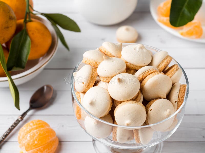 La meringue de biscuits en mandarines d'un vase en verre avec le vert part dans un plat sur le fond blanc images libres de droits La meringue de biscuits en mandarines d'un vase en verre avec le vert part dans un plat sur le fond blanc images libres de droits