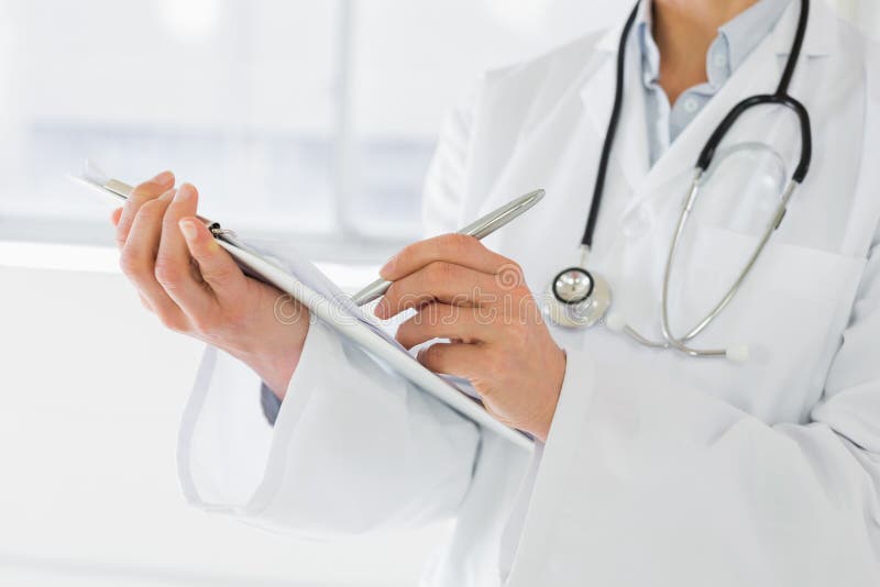 La metà di sezione di una scrittura femminile di medico riferisce immagine stock La metà di sezione di una scrittura femminile di medico riferisce immagine stock