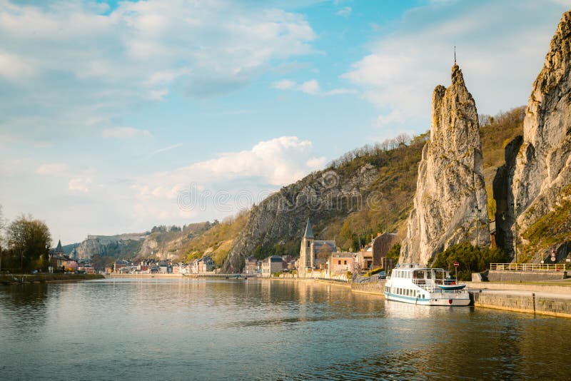 Panoramic view of scenic Meuse river with famous Bayard Rock and the historic town of Dinant in the background in beautiful golden evening light at sunset in spring, Wallonia, Belgium. Panoramic view of scenic Meuse river with famous Bayard Rock and the historic town of Dinant in the background in beautiful golden evening light at sunset in spring, Wallonia, Belgium