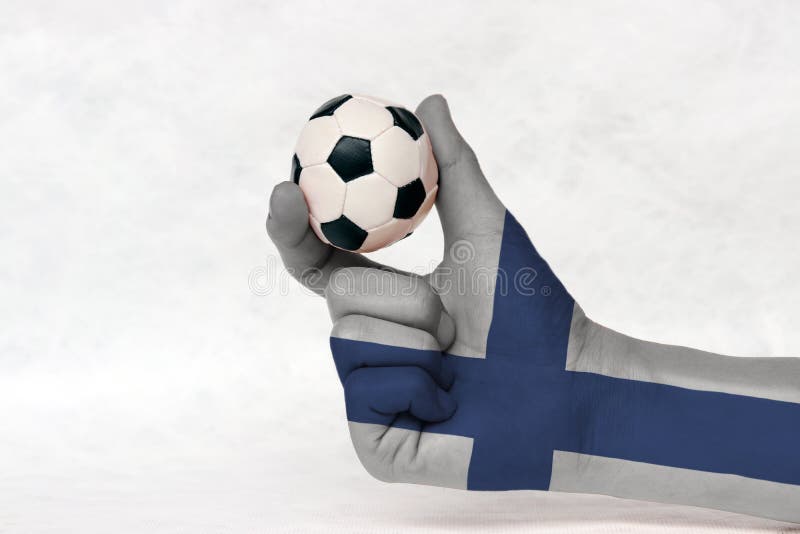 La mini bola del fútbol en la mano pintada bandera de Finlandia, la lleva a cabo con el finger dos en el fondo blanco fotografía de archivo libre de regalías La mini bola del fútbol en la mano pintada bandera de Finlandia, la lleva a cabo con el finger dos en el fondo blanco fotografía de archivo libre de regalías