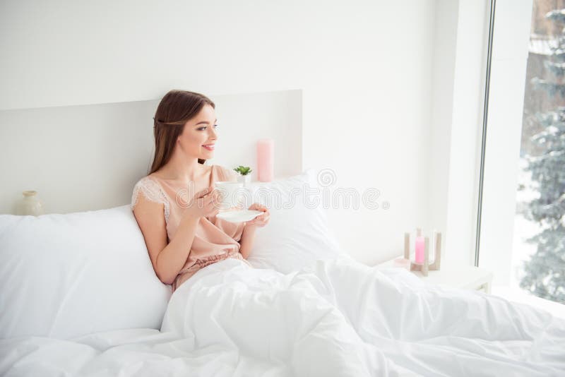 La mirada de mentira de la bebida de la taza de la mano del control de la materia textil de la cama de la juventud del retrato de fotos de archivo libres de regalías La mirada de mentira de la bebida de la taza de la mano del control de la materia textil de la cama de la juventud del retrato de fotos de archivo libres de regalías