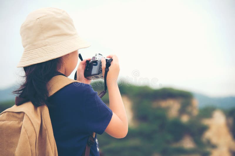 La mochila de la muchacha de los niños caucásicos y la cámara asiáticas sonrientes felices el sostenerse para toman un incorporar fotografía de archivo libre de regalías La mochila de la muchacha de los niños caucásicos y la cámara asiáticas sonrientes felices el sostenerse para toman un incorporar fotografía de archivo libre de regalías
