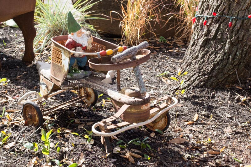 La monte de gnome de jardin de vieux enfants rouillés à quatre roues vont à vélo images libres de droits La monte de gnome de jardin de vieux enfants rouillés à quatre roues vont à vélo images libres de droits