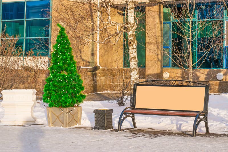 La moquerie de rue, panneau d'affichage vide à côté des arbres de Noël décorent les rues de la ville pendant la nouvelle année, image libre de droits La moquerie de rue, panneau d'affichage vide à côté des arbres de Noël décorent les rues de la ville pendant la nouvelle année, image libre de droits