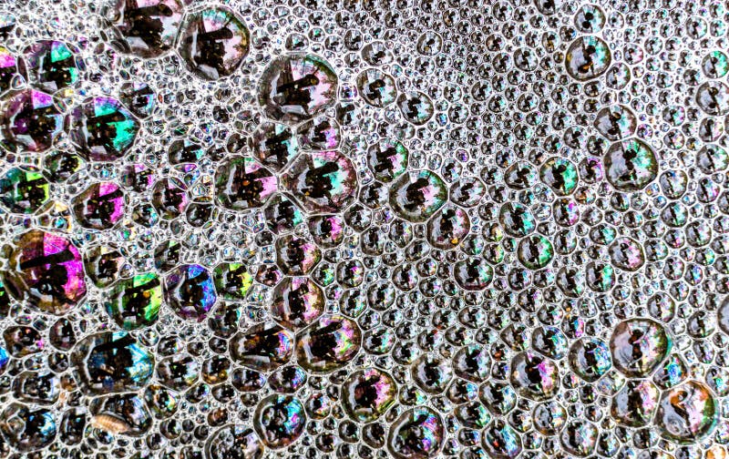 La mousse multicolore de savon bouillonne sur la surface d'un magma de l'eau créent photo stock La mousse multicolore de savon bouillonne sur la surface d'un magma de l'eau créent photo stock