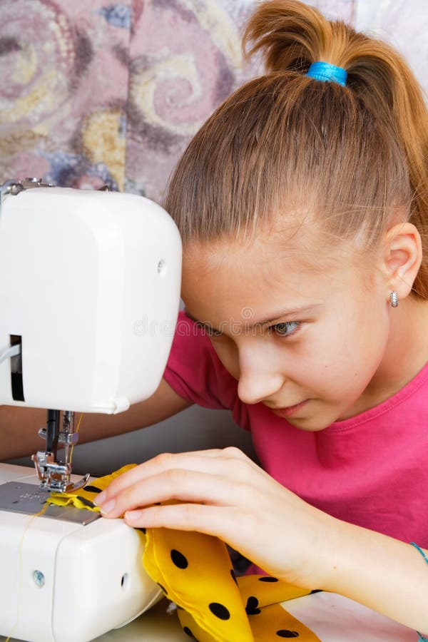 La muchacha aprende coser fotografía de archivo La muchacha aprende coser fotografía de archivo