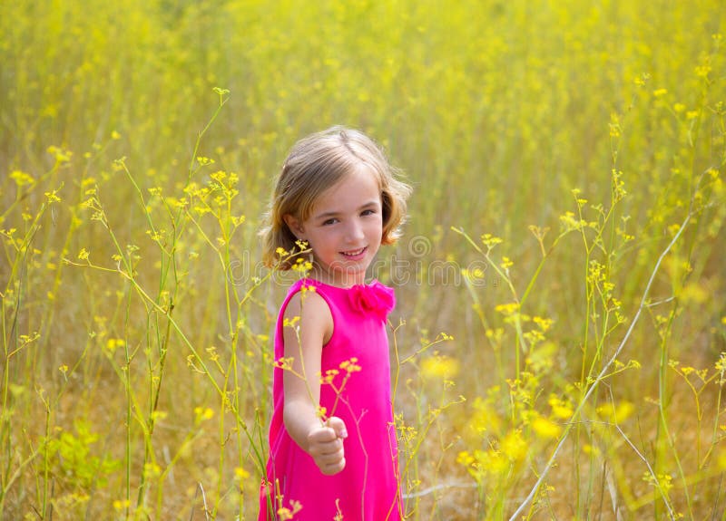 La muchacha del niño del niño en campo de flores del amarillo de la primavera y el rosa se visten imagenes de archivo La muchacha del niño del niño en campo de flores del amarillo de la primavera y el rosa se visten imagenes de archivo