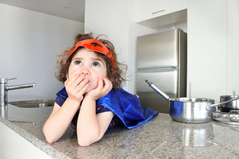 La muchacha del super héroe piensa en qué comer o cocinar fotos de archivo La muchacha del super héroe piensa en qué comer o cocinar fotos de archivo