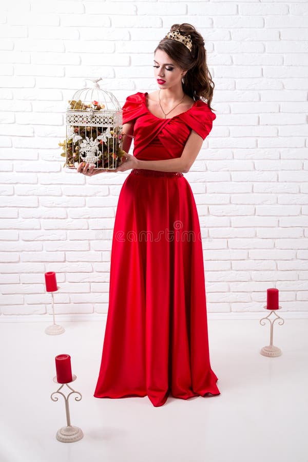 La Muchacha Elegante Hermosa En Un Vestido Rojo Largo Y Zapatos Lleva a Cabo Un Bir Foto de archivo - Imagen de silla, paro: 94043550 La Muchacha Elegante Hermosa En Un Vestido Rojo Largo Y Zapatos Lleva a Cabo Un Bir Foto de archivo - Imagen de silla, paro: 94043550