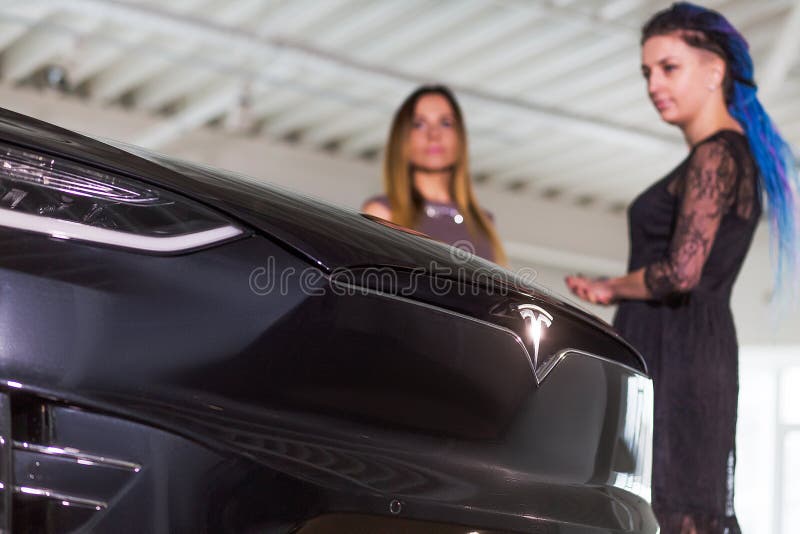 La muchacha est? comprando Tesla costoso Electromobile en sal?n del autom?vil foto de archivo libre de regalías La muchacha est? comprando Tesla costoso Electromobile en sal?n del autom?vil foto de archivo libre de regalías