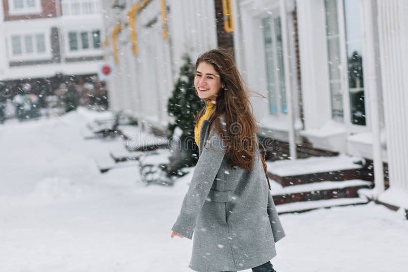 La muchacha europea romántica en capa gris larga cruza la calle y la mirada de las nevadas Retrato al aire libre de rubio soñador fotos de archivo libres de regalías La muchacha europea romántica en capa gris larga cruza la calle y la mirada de las nevadas Retrato al aire libre de rubio soñador fotos de archivo libres de regalías