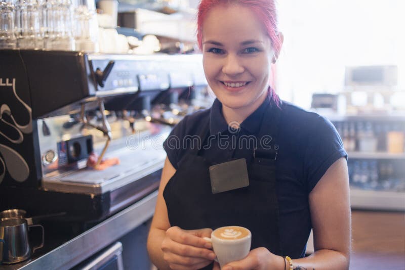 La muchacha feliz Barista da el café a los clientes imagenes de archivo La muchacha feliz Barista da el café a los clientes imagenes de archivo