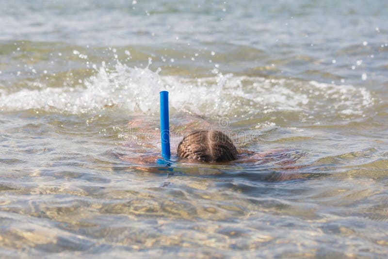 La muchacha flota en el agua con la máscara y el tubo respirador fotos de archivo La muchacha flota en el agua con la máscara y el tubo respirador fotos de archivo