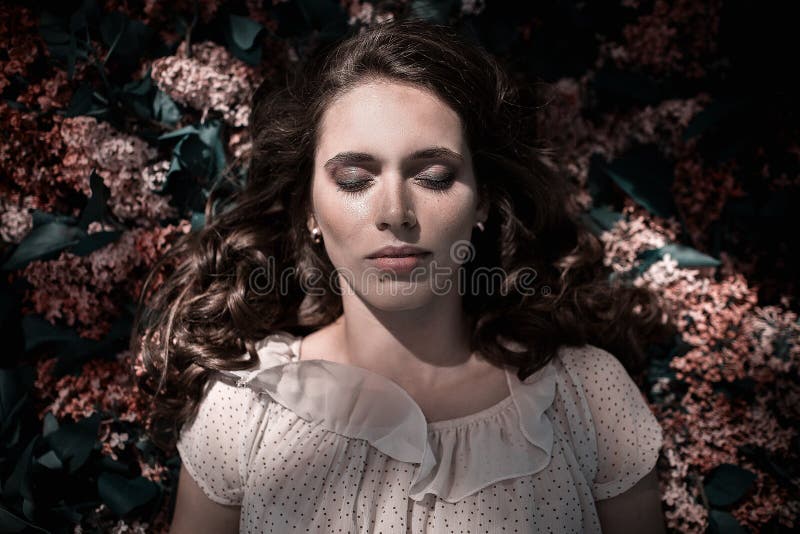 La muchacha hermosa adolescente que miente en lila florece el fondo Ascendente cercano del retrato imagen de archivo libre de regalías La muchacha hermosa adolescente que miente en lila florece el fondo Ascendente cercano del retrato imagen de archivo libre de regalías