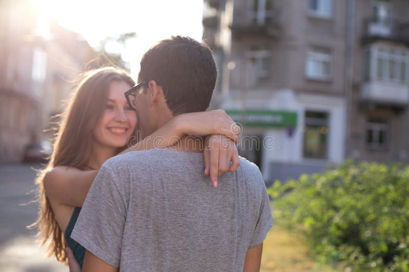La muchacha hermosa joven mira al muchacho que abraza el suyo y la sonrisa imagen de archivo libre de regalías La muchacha hermosa joven mira al muchacho que abraza el suyo y la sonrisa imagen de archivo libre de regalías