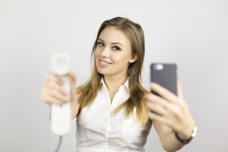 La muchacha hermosa sostiene dos teléfonos fotos de archivo libres de regalías