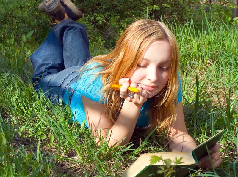 Girl reads the book lying down. Girl reads the book lying down.