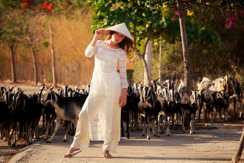 la muchacha rubia en vietnamita viste el sombrero de los tactos contra multitud fotografía de archivo libre de regalías la muchacha rubia en vietnamita viste el sombrero de los tactos contra multitud fotografía de archivo libre de regalías