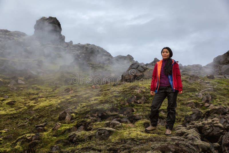 La muchacha se coloca en las rocas que fuman de Landmannalaugar en Islandia fotos de archivo libres de regalías La muchacha se coloca en las rocas que fuman de Landmannalaugar en Islandia fotos de archivo libres de regalías