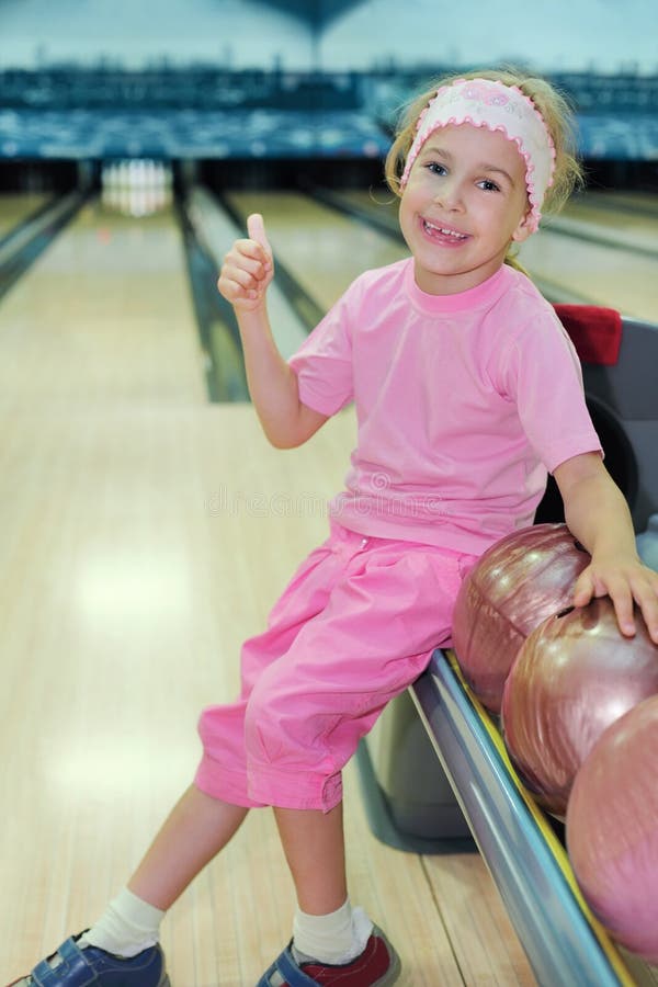 La muchacha se sienta y manosea con los dedos para arriba en club del bowling fotos de archivo La muchacha se sienta y manosea con los dedos para arriba en club del bowling fotos de archivo
