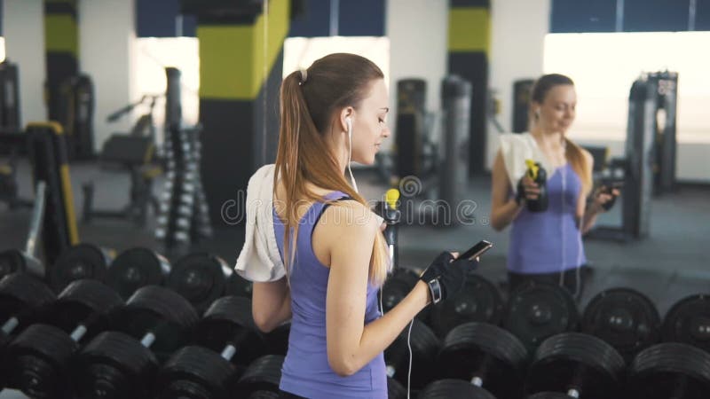 La muchacha utiliza el teléfono en el gimnasio