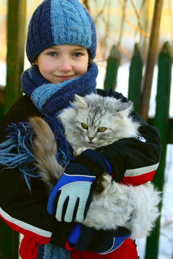 The girl holds on hands of a cat. The girl holds on hands of a cat